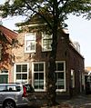 Pand met hoge kap waarvoor ingezwenkte afgeknotte halsgevel