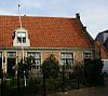 Eenvoudige woning onder zadeldak met toppilaster ter halverwege