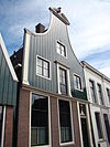 Huis, voorzien van een houten klokgevel