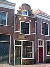Pand met smalle trapgevel, eindigend in halfrond bovenstuk