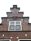 Pand met gedodekopte trapgevel, middenpilasters op leeuwenmasker rustend