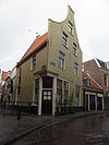 Pand met gepleisterde klokgevel onder hoog zadeldak