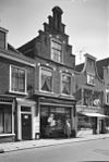 Pand met trapgevel, midden pinakel geleed, rustend op twee consoles, bogen met natuurstenen blokken versierd boven de vensters