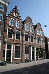 Huis Janstraat Haarlem -  Janstraat 61 Haarlem, Netherlands. Op de gevel een beeltenis van een man en een vrouw, waarschijnlijk de bewoners. Naast hen de wapens (van links naar rechts) van Haarlem, Amsterdam, Leiden en Den Haag.