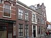 Statig patriciershuis met uit- en inspringende gevelpartijen, rechte kroonlijst; middenpartij met houten gebeeldhouwde versieringen, inwendig rechts en links van de middengang binnenplaatsen met houten betimmeringen met secreten. Fraaie stucwerken in de gang en deuren