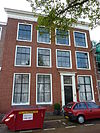 Pand met brede lijstgevel met tandingen, natuurstenen pijlers