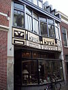 Loghem Ridderstraat -  Ridderstraat 20, Centrum Haarlem, Woning, winkel en werkplaats ontworpen door J. van Loghem, 1924. Nu is in het pand een uitdragerij gevestigd, daarvoor een drankenhandel. Oorspronkelijk was er een meubelwerkplaats gevestigd. De ramen op de eerste verdieping konden oorspronkelijk als een harmonica openschuiven of dat nog steeds kan??? Geen idee. Het houtwerk was voorheen in de oorspronkelijke 20'er jaren kleuren geverfd: lindegroen, steenoranje, gebroken wit en zwart. De huidige bewoners hebbe…