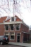 Pand met gepleisterde lijstgevel, beneden gemoderniseerd