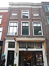 Pand met in- en uitspringende brede kroonlijst, steen met cartouche 1696