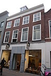Pand met rechte kroonlijst met tandingen. Beneden verbouwd