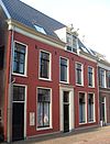 Pand met lijstgevel, zadel in topgevel eindigend, beneden deels verbouwd