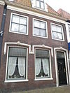 Met 19e-eeuws stucornament opgesierde laat-18e-eeuwse gevel voor ouder pand