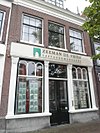 Huis met eenvoudige lijstgevel; pui gewijzigd