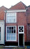 Smal pandje waarvan de vensters roedenverdeling hebben. Op de verdieping spaarveld
