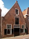 Pakhuis onder hoog zadeldak, met eenvoudige puntgevel. Gevelsteen de Mosterdmolen