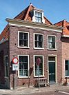 Hoekpand onder hoog zadeldak met rechte kroonlijst