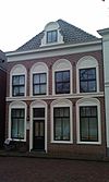 Pand, met voorgevel, voorzien van vensters in rondboognissen, geprofileerde puibalk en houten kroonlijst