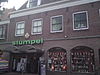 Zes traveeën breed met rechte kroonlijst en twee dakkapellen voor drie oudere panden waarvan een de top behouden heeft. Pui modern