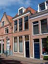 Huis met hoogst eenvoudige 19e-eeuwse gevel met rechte kroonlijst