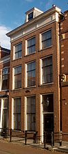 Huis met eenvoudige gevel met rechte kroonlijst voor dwarskap. Stoep met eenvoudig stoephek