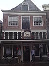 Pand met gepleisterde verdieping waarin oud luik; thans recht afgesloten, oude kap