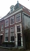 Nieuwendam 18, Hoorn -  Simple late 18th or early 19th century house with entrance surrounded by decorative listing.  Eenvoudig laat 18e- vroeg 19e eeuws huis met omlijste ingang 