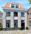 Gepleisterd hoekpand met verdieping en schilddak