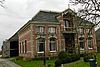 Boerderij in een vermenging van neo-renaissance en art nouveau-motieven, uitgevoerd in verscheidene kleuren baksteen
