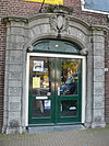 WLM - M.arjon - Purmerend Achterdijk bij 16 - Natuurstenen poortomlijsting met pilasters en een getoogde kroonlijst met wapenschild 