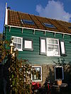 WLM - M.arjon - Marken Grotewerf 21 - Houten huis met eenvoudige topgevel. Daklijst op consoles. Vormt een geheel met buurnummer 22. 