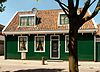 Houten huis onder een met de straat parallel gelegen zadeldak