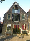 Kranensteeg 7 v02 -  Kranensteeg 7 in Deventer (Netherlands) is national heritage: a warehouse with gable roof with a spout hemisphere finished stucco facade. A hoisting canopy in line with the facade warehouse shutters. Ground floor altered.  Kranensteeg 7 in Deventer (Nederland) is een rijksmonument: een pakhuis onder zadeldak met een halfrond beÃ«indigde gepleisterde tuitgevel. In de as van de gevelpakhuisluiken een hijskap. Begane grond gewijzigd.
