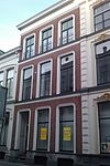 Pand dat deel uitmaakt van een in het derde kwart van de 19e eeuw als een symmetrisch geheel ontworpen straatwand
