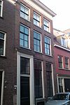 Onderkelderd pand, eenvoudige voordeuromlijsting en bovenlicht