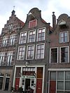 Huis met klokgevel, de top met half cirkelvormige bekroning met natuurstenen lijst