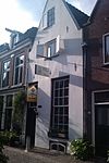 Onderkelderd woonhuis zonder verdieping onder met pannen gedekt zadeldak tussen tuitgevels