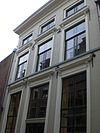 Fors onderkelderd pand met gepleisterde lijstgevel, in jaarankers gedateerd 1621