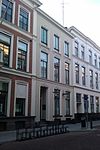 Pand dat onderdeel is van een in het derde kwart van de 19e eeuw als een symmetrisch geheel ontworpen straatwand
