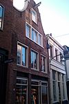 Pand met gedeeltelijk ontpleisterde klokgevel