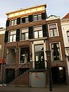 Huis met lijstgevel met voorste deel van het pand onder schilddak met hoekpirons