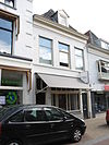 Pand met gepleisterde lijstgevel en jongere winkelruit