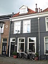 Pand met gepleisterde lijstgevel onder schilddak