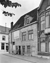 Hoekpand met gepleisterde gevels met houten kroonlijst aan de Graafschap onder zadeldak met voorschild