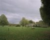 Overzicht van de boerderij met rieten dak, bijgebouwen en de omgeving, links de ingestorte schuur