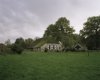 Overzicht van de boerderij met rieten dak, bijgebouwen en de omgeving