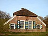 Eenvoudig begin 20e-eeuws boerderij-complex bestaande uit boerderij, bakhuis en schuur, gelegen op en behorend tot landgoed 't Reelaer