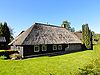 Klein woonhuis met houten gevels en aangebouwde berging onder schilddak