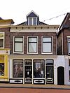 Huis met gevel met rechte kroonlijst en gewijzigde onderpui