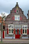 Huis met gevel met in- en uitgezwenkte zijkanten, top- en hoekpilasters op zandstenen consoles en bakstenen tandlijst (Telvorenshuis)