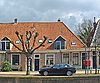 Verdiepingloos pand onder een kap met de nrs. 15-20
